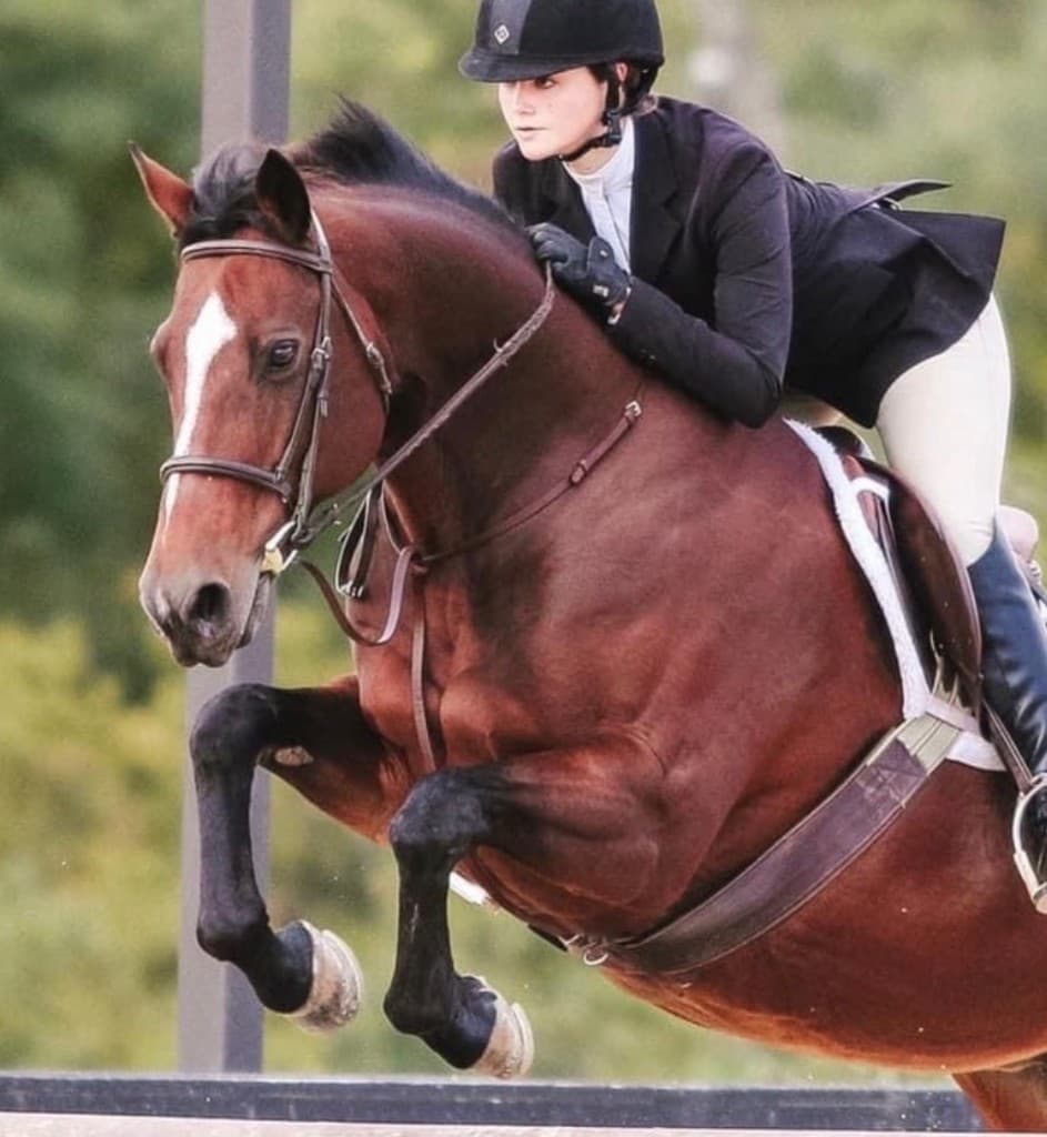 Sarah competing over a jump